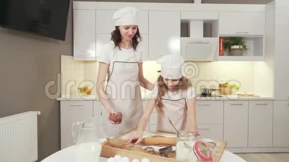 妈妈穿着厨房围裙和帽子教女儿做饭视频的预览图