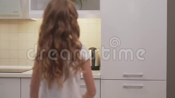 可爱的小女孩打开冰箱取橙汁视频的预览图