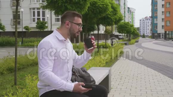 男人使用智能手机在户外喝咖啡视频的预览图