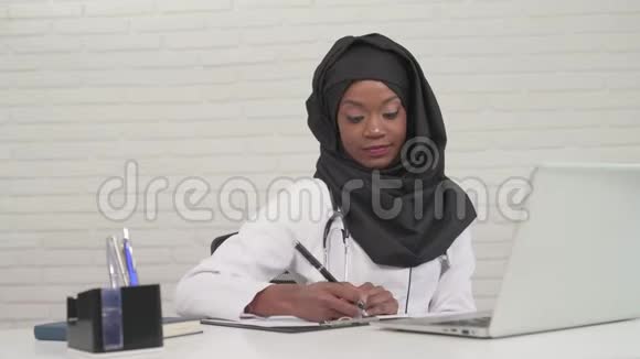 女医生在笔记本电脑上写笔记和打字视频的预览图