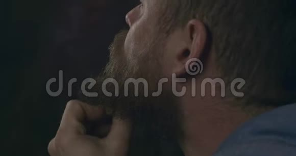 大胡子的人用木梳梳理他的胡子和胡子电影4K录像视频的预览图