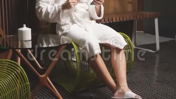 健康有魅力的男人在水疗后在椅子上放松喝绿茶视频的预览图