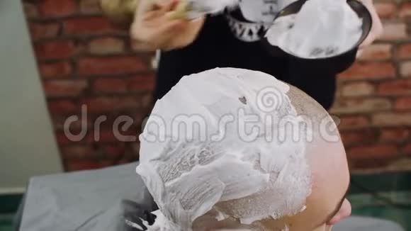 专业发型师在客户头上涂抹剃须泡沫视频的预览图