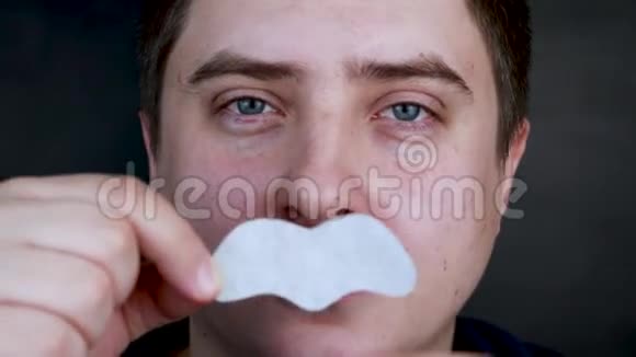 一个男人穿上并从黑点上取下一条鼻子的带子从黑头和喜剧片上清理煤炭的概念视频的预览图