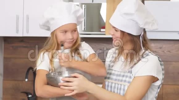 年轻的母亲和女儿在厨房里做面团视频的预览图