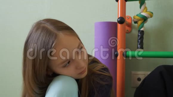 体贴的年轻女孩坐在游戏室里视频的预览图