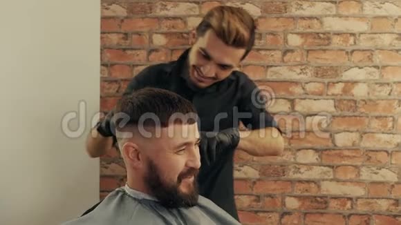 理发店里一个满脸胡子的快乐男人在和理发师说话视频的预览图