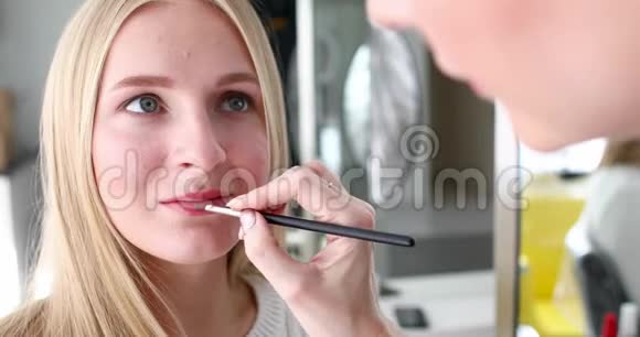 美容师艺术家为金发女性画红唇视频的预览图