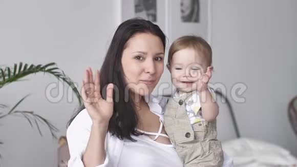 幸福家庭的写照年轻的母亲和蹒跚学步的男婴在一起交流看着镜头微笑视频的预览图
