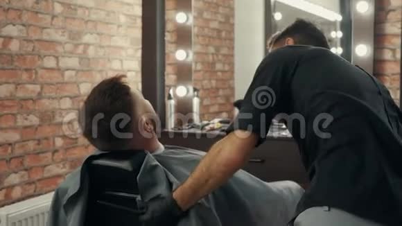 专业专注的理发师拉直椅与客户视频的预览图