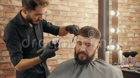 理发店年轻的理发师给英俊的男客户梳洗打扮视频的预览图
