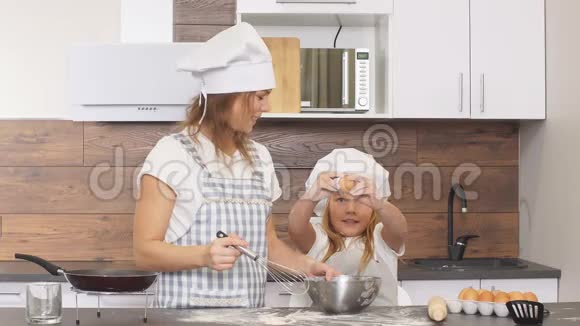 女孩打破鸡蛋做面粉与母亲隔离厨房视频的预览图
