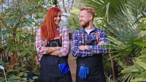 有魅力的园丁红头发的女人和漂亮的男人园丁在镜头前看着直笑的大视频的预览图