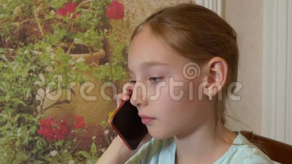 肖像少年女孩在国内用手机交谈面对年轻女孩在家里打智能手机视频的预览图