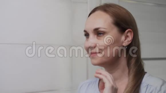 浴室里镜子前的白人女人洗脸护肤健康视频的预览图