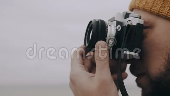 特写幸福的欧洲摄影师男子拍照与复古风格的电影相机在阴秋日慢镜头视频的预览图