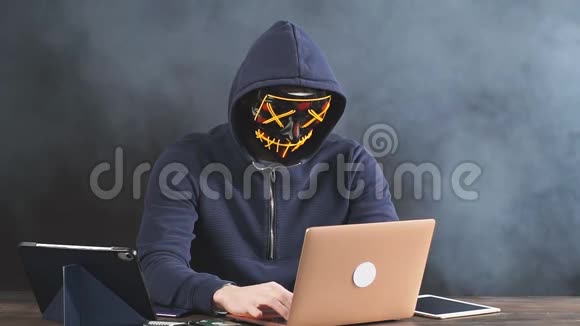 头罩上的黑客黑烟背景下的黑客视频的预览图