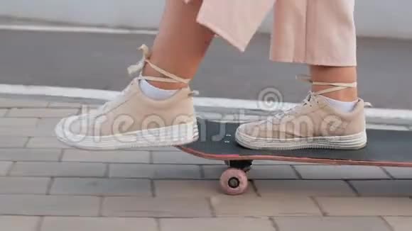 穿着米色运动鞋的女人的美腿在滑板上视频的预览图