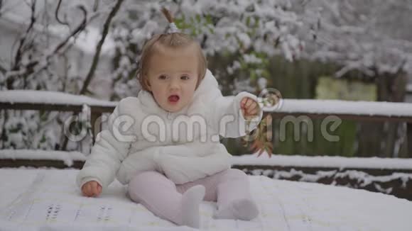 喜笑颜开的宝贝女孩坐在雪地公园小男孩享受第一场雪视频的预览图