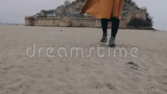 在史诗圣米歇尔慢动作MontSaintMichel中一位时尚快乐旅行博客女性在柔软的沙滩上行走视频的预览图