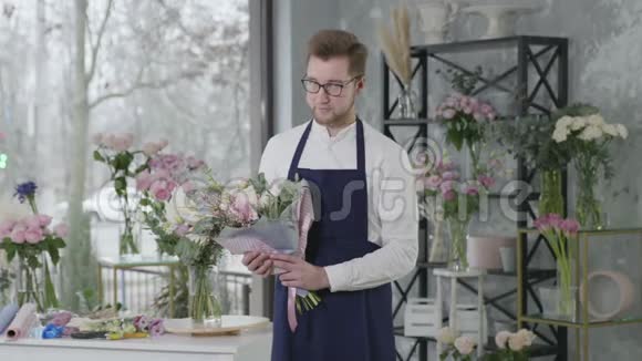 一个微笑的迷人男孩的肖像代表一个性别职业花店花束在一个视频的预览图