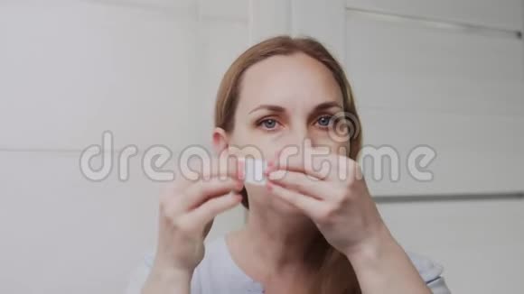 成年女性闭上眼睛把胶原蛋白垫放在眼睛下面看着相机视频的预览图