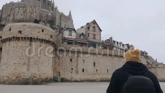 镜头围绕着快乐兴奋的旅游者移动背包被史诗般的圣米歇尔城堡堡慢动作惊呆了视频的预览图
