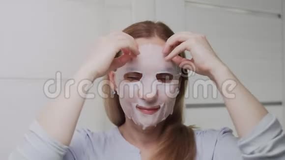 一个成年女人看着摄像机摘下她脸上的面具视频的预览图