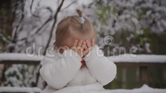 喜笑颜开的宝贝女孩坐在雪地公园小男孩享受第一场雪视频的预览图