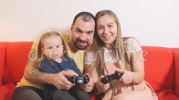快乐的男人女人和女儿玩电子游戏视频的预览图