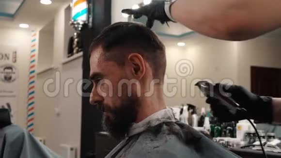 在理发店用电动剃须刀剃脖子的胡子男人理发师用电剃男性颈部视频的预览图