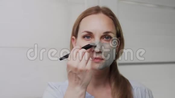 合上成年女子脸上涂着黏土面具看着镜头视频的预览图