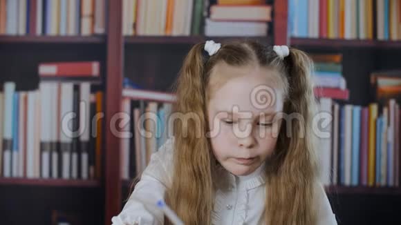 有雀斑的女学生在书架上写字微笑的学生女孩在教室里写作业视频的预览图