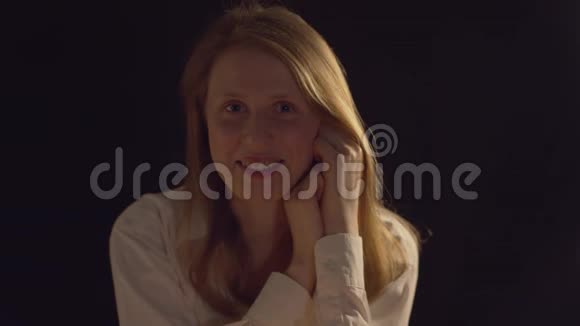 一个年轻漂亮女人在黑暗中的肖像视频的预览图