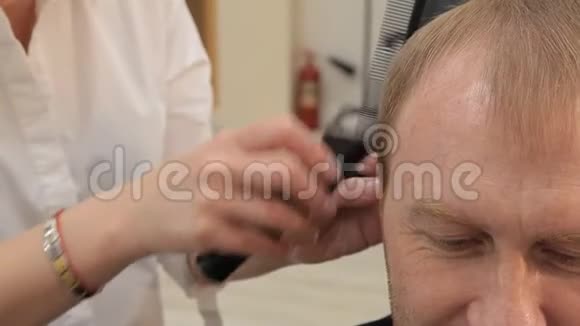 一个女人巴伯用一个无电绳剪刀剪一个男人头发4她把顾客发型等同于发型视频的预览图