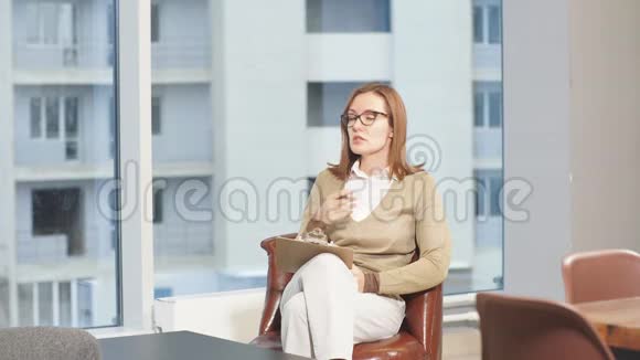 年轻白种人女心理学家坐在自己办公室的皮椅上的肖像视频的预览图