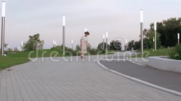 年轻的女滑板运动员试图耍花招在公园里摔倒视频的预览图