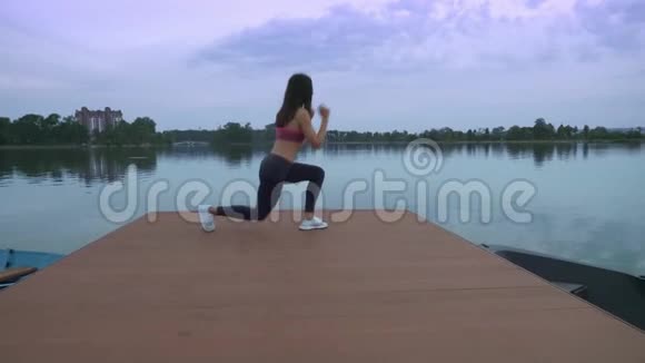 健身妇女在湖边码头上做午餐视频的预览图