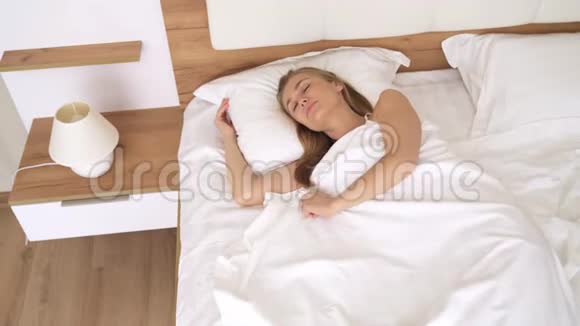 年轻的金发女郎在床上睡觉视频的预览图