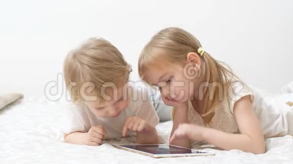 可爱的白种人儿童使用现代小工具手里拿着平板电脑视频的预览图