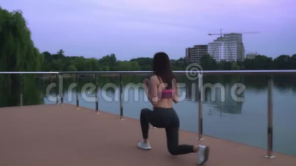 健身妇女在湖边码头上做午餐视频的预览图