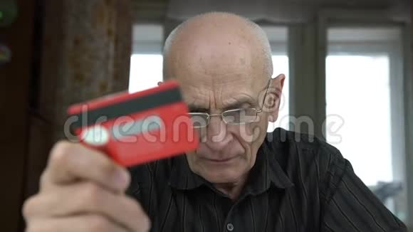 戴眼镜的老人看卡片和向下的近景视频的预览图