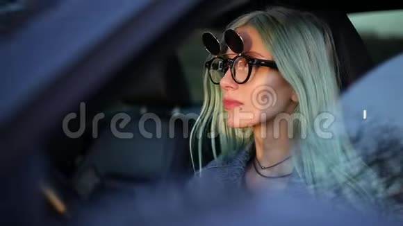 年轻司机的画像车内金发女孩饮用钢热生态瓶的水戴着时髦的太阳镜视频的预览图