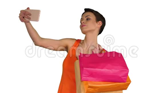 迷人的年轻女人拿着不同的空白购物袋在白色背景上自拍视频的预览图