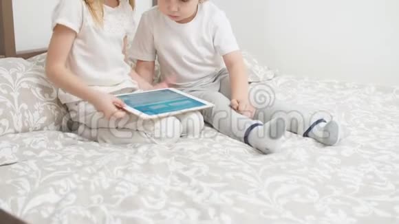 可爱的白种人儿童使用现代小工具手里拿着平板电脑视频的预览图