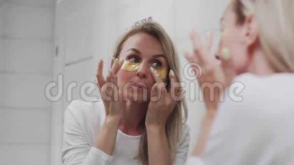 女人在她的眼睛里取出金色的胶原蛋白视频的预览图