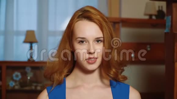 穿着蓝色连衣裙的漂亮性感女孩红头发顽皮的样子正在走微笑着看着相机慢点视频的预览图