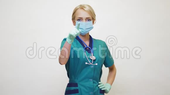 戴防护面罩和乳胶手套的女医生用手指指着观众视频的预览图