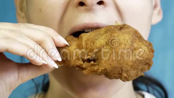 特写年轻女人吃快餐鸡块翅膀和鸡腿视频的预览图