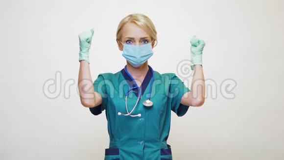 戴防护面罩橡胶或乳胶手套的女医生是的胜利的手势视频的预览图